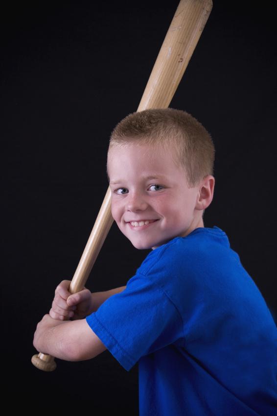 Cute little eight year old boy holding a baseball bat.