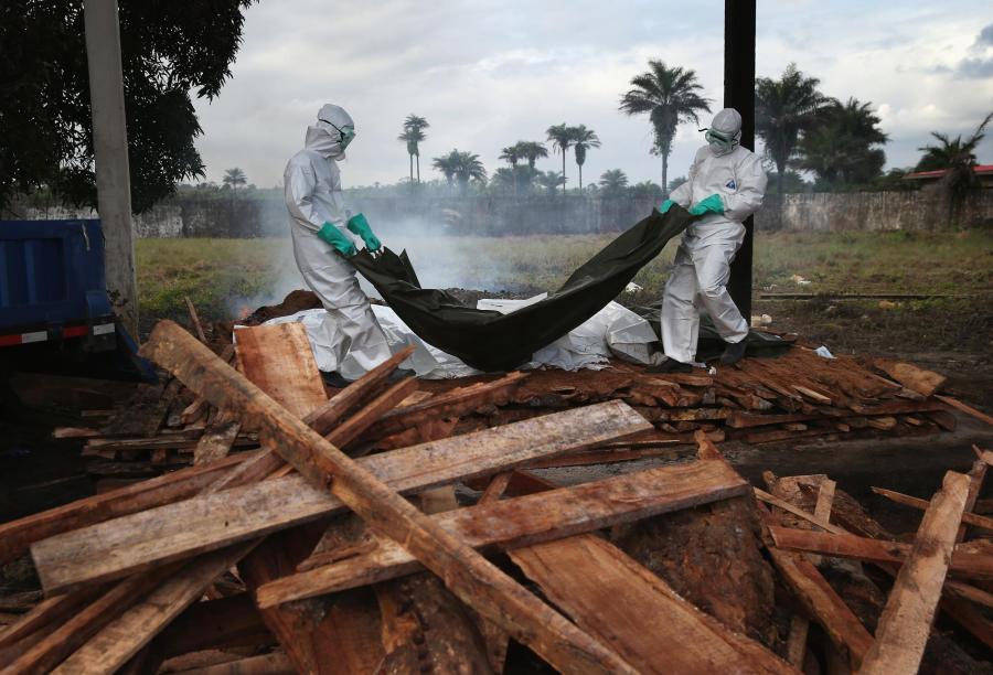 A burial team from the Liberian Ministry of Health unloads the bodies of Ebola
