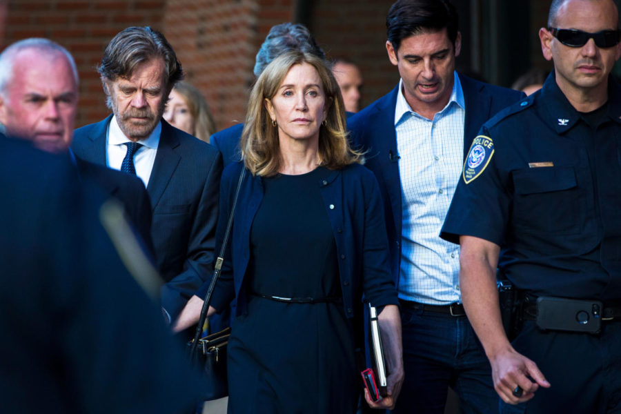 BOSTON, MA - SEPTEMBER 13: Felicity Huffman, right, and her husband, William H. Macy, walk out of John Joseph Moakley United States Courthouse in Boston, MA on Sept. 13, 2019. Huffman was sentenced to 14 days in prison and community service for her role in the college admissions scandal. (Photo by Nic Antaya for The Boston Globe via Getty Images)